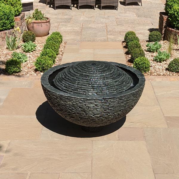 large grey slate water feature raised above slate the patio