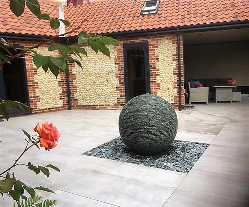 1m Grey Watersphere™ with loose slate chippings below framed in a rectangle. This formed part of a new raised patio design in Norfolk.
