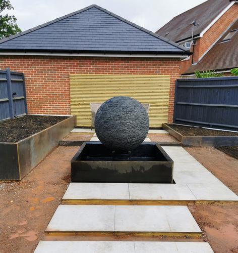 1m Grey Watersphere™ set on a raised square Corten steel framed pond. Surrey.