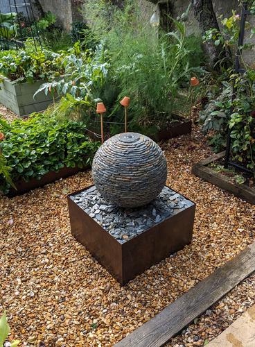 500mm Rustic Watersphere™ on a square steel surround. Installed in a beautiful garden in Portcatho, Cornwall which has matching steel edging on the vegetable patches.
