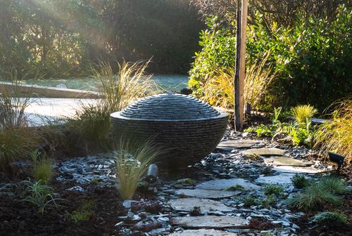 Grey slate over flowing semi-sphere; a unique water feature design by Jeremy Hastings