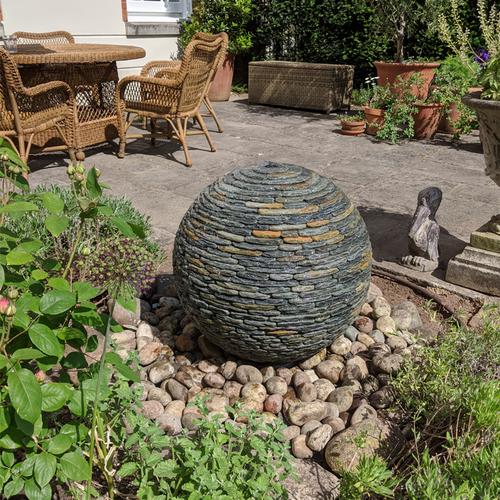 rustic medium water sphere on round cobble stones