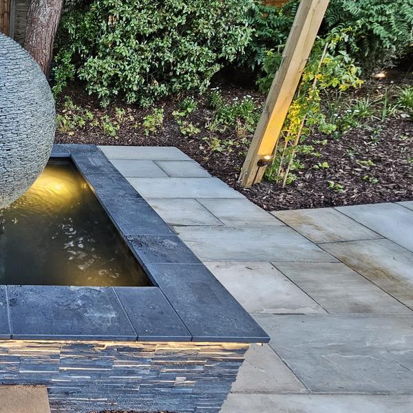 Jeremy Hastings 1.2m grey slate ball water feature on a pool