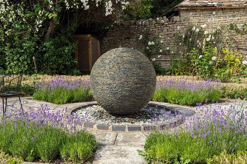 Jeremy Hastings 1.2m extra large rustic slate ball water feature, amongst lush lavender planting