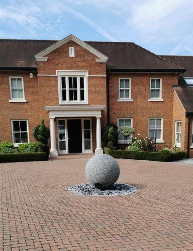 Jeremy Hastings 1m grey slate ball sculpture on large bricked driveway