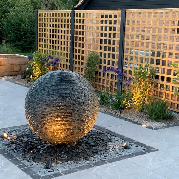 Jeremy Hastings 1m grey slate ball water feature in a modern garden design by David Kent