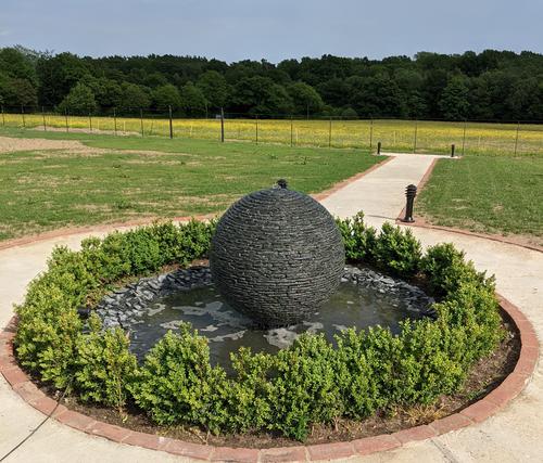 Jeremy Hastings 1m Large grey slate ball water feature, with a box hedging border, Lamberhurst