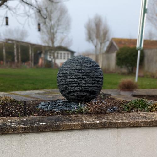 Jeremy Hastings 500mm extra small grey slate ball water feature, raised flower bed, stockbridge