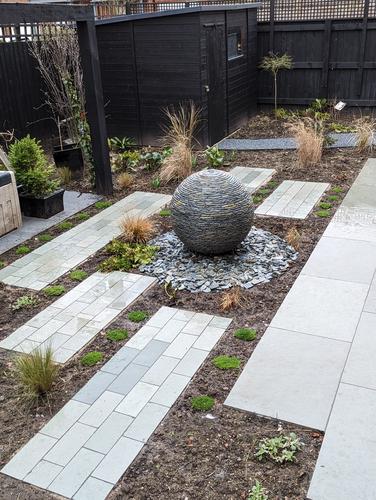 Jeremy Hastings 800mm rustic slate ball water feature, landscaped partially paved garden, Manchester.
