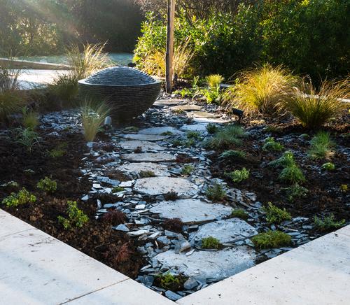 Jeremy Hastings bespoke over-slowing semi sphere water feature, sat at the end of a sweeping slate paved path