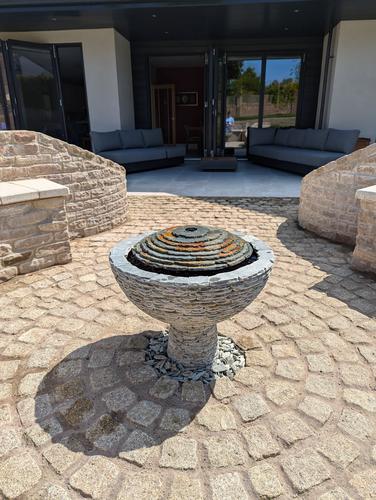 Jeremy Hastings bespoke 650mm rustic slate semi sphere water feature on sandstone bricked patio