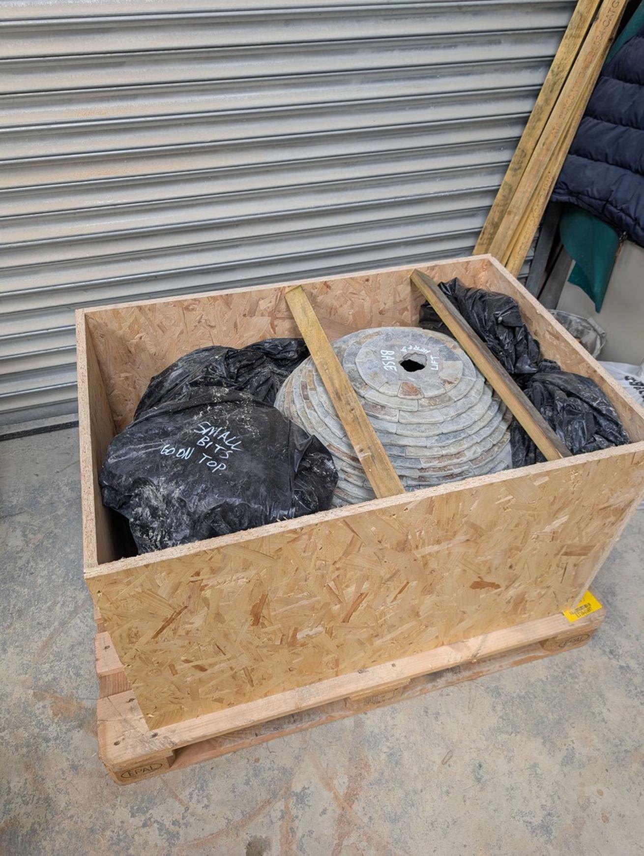 A Jeremy Hastings slate ball water feature in a pallet box ready to be shipped.