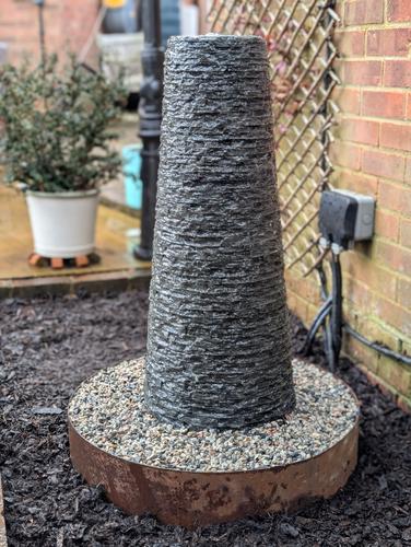 Jeremy Hastings Cornish chimney water feature in a flower bed