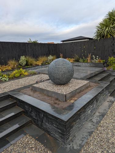 800mm Grey Watersphere with a partially sunken steel base.